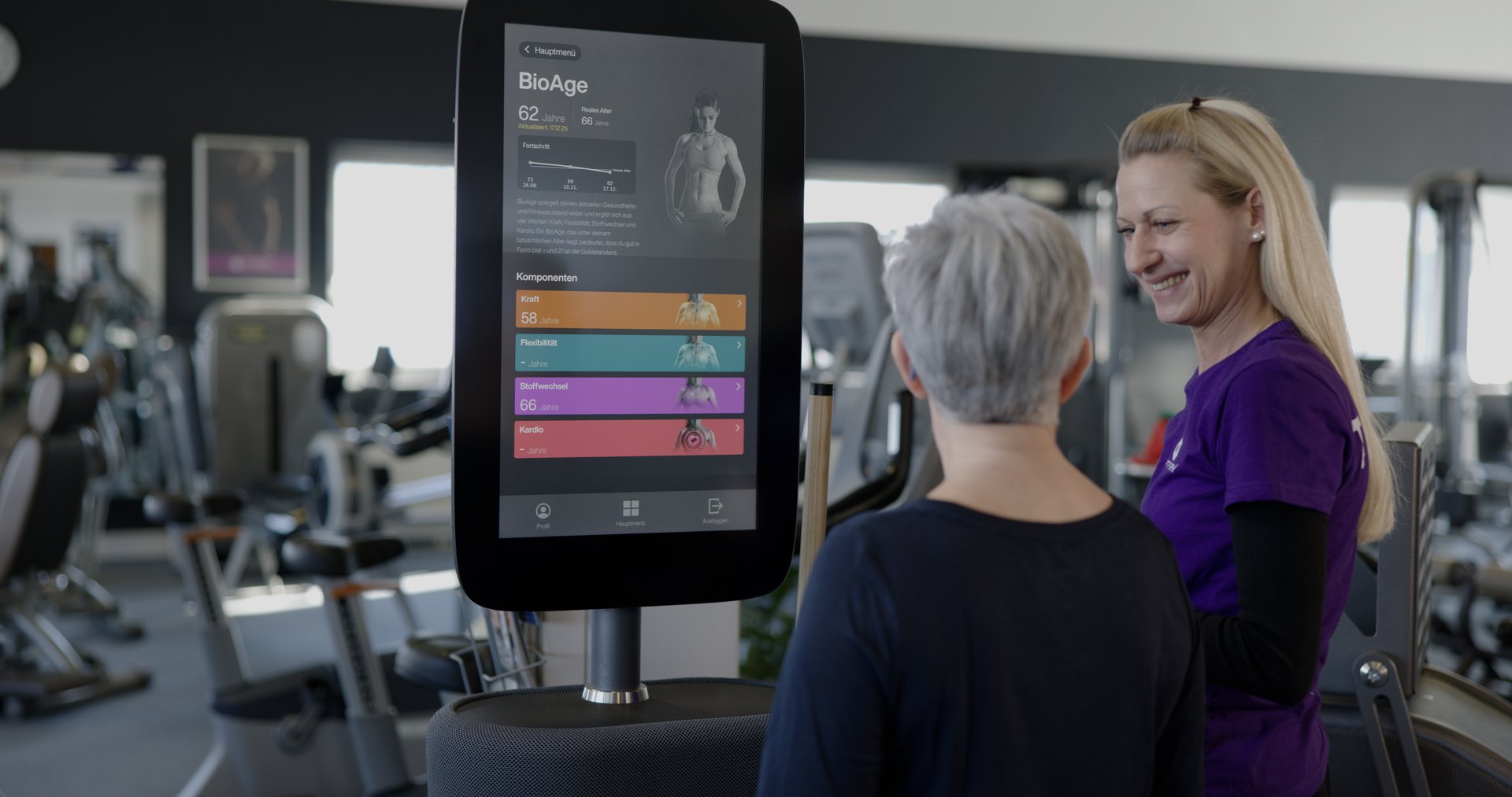 Eine FITfactory-Trainerin im Gespräch mit einer trainierenden Person im Studio.